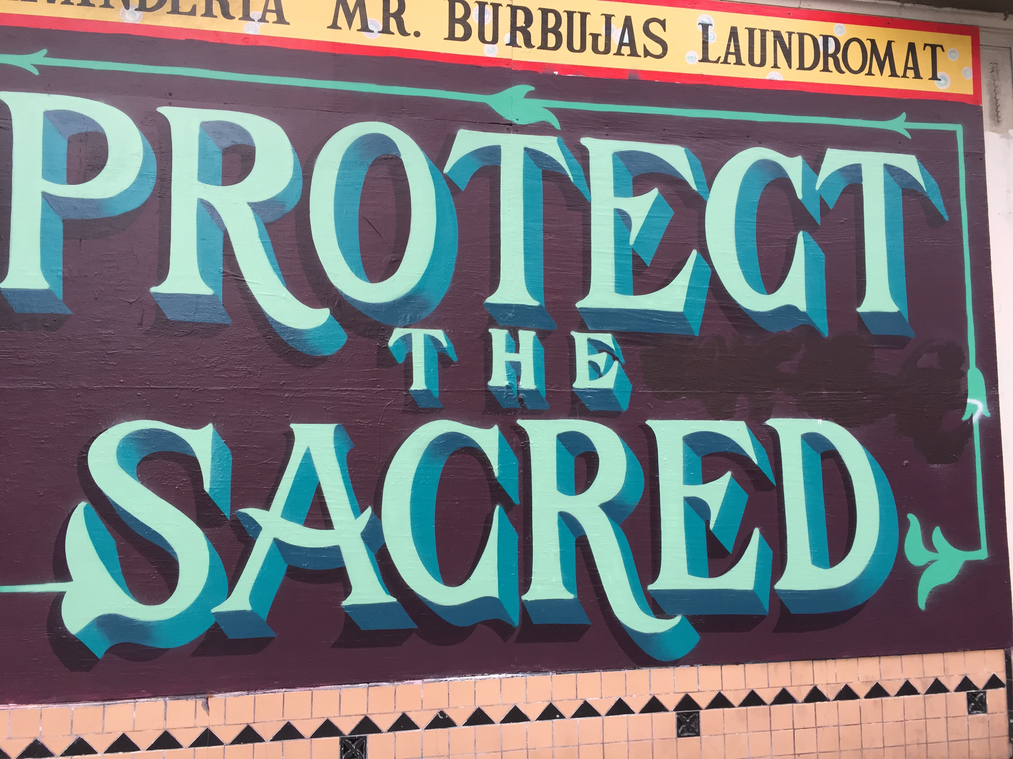 Protect the Sacred type mural with Mr. Burbujas sign painted above